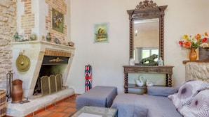 A cozy living room with a fireplace, a large mirror, and a comfortable sofa. - Babelle by Interhome (Gaillan-en-Médoc)