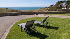 A patio with two lounge chairs overlooking a coastal view. - Blaues Meer by Interhome (Plouarzel)