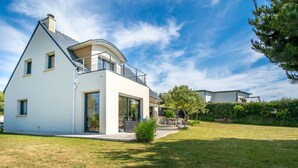A modern two-story house with a large patio area, a covered outdoor seating area, and a well-maintained lawn. - Vacation home Hidel by Interhome (Plouarzel)