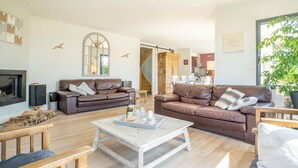 A spacious living room with two brown leather sofas, a white coffee table, and a wooden TV stand. - Vacation home Hidel by Interhome (Plouarzel)