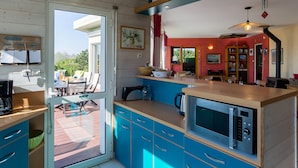 Una cocina moderna con armarios azules, microondas y cafetera.