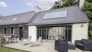 Une maison dotée d’un patio aménagé avec du mobilier d’extérieur et une table à manger.