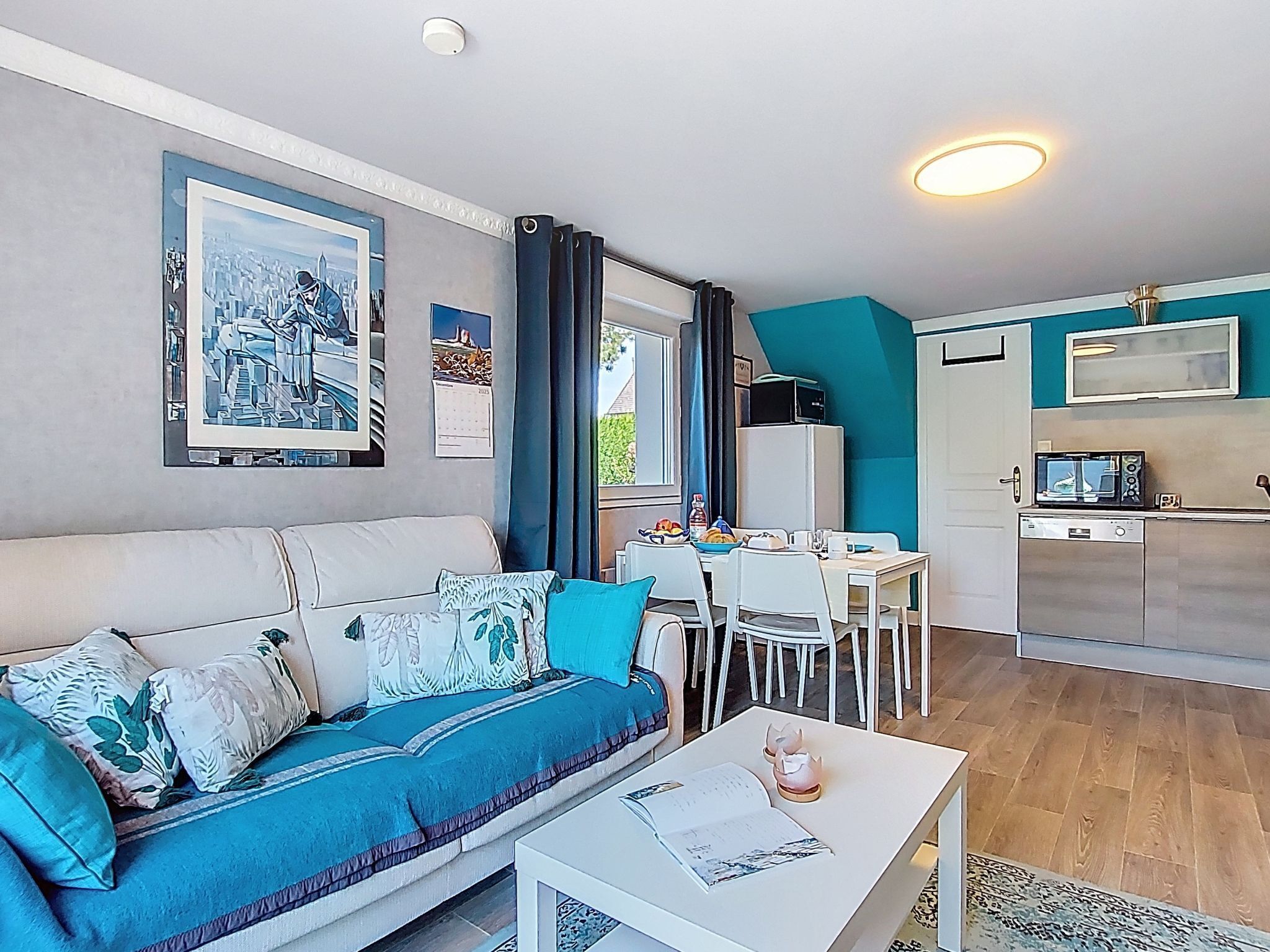 A compact living space with a sofa, dining table, and kitchenette.