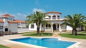 A large, white building with a pool, palm trees, and a clear blue sky. - Memphis by Interhome (Miami Platja)