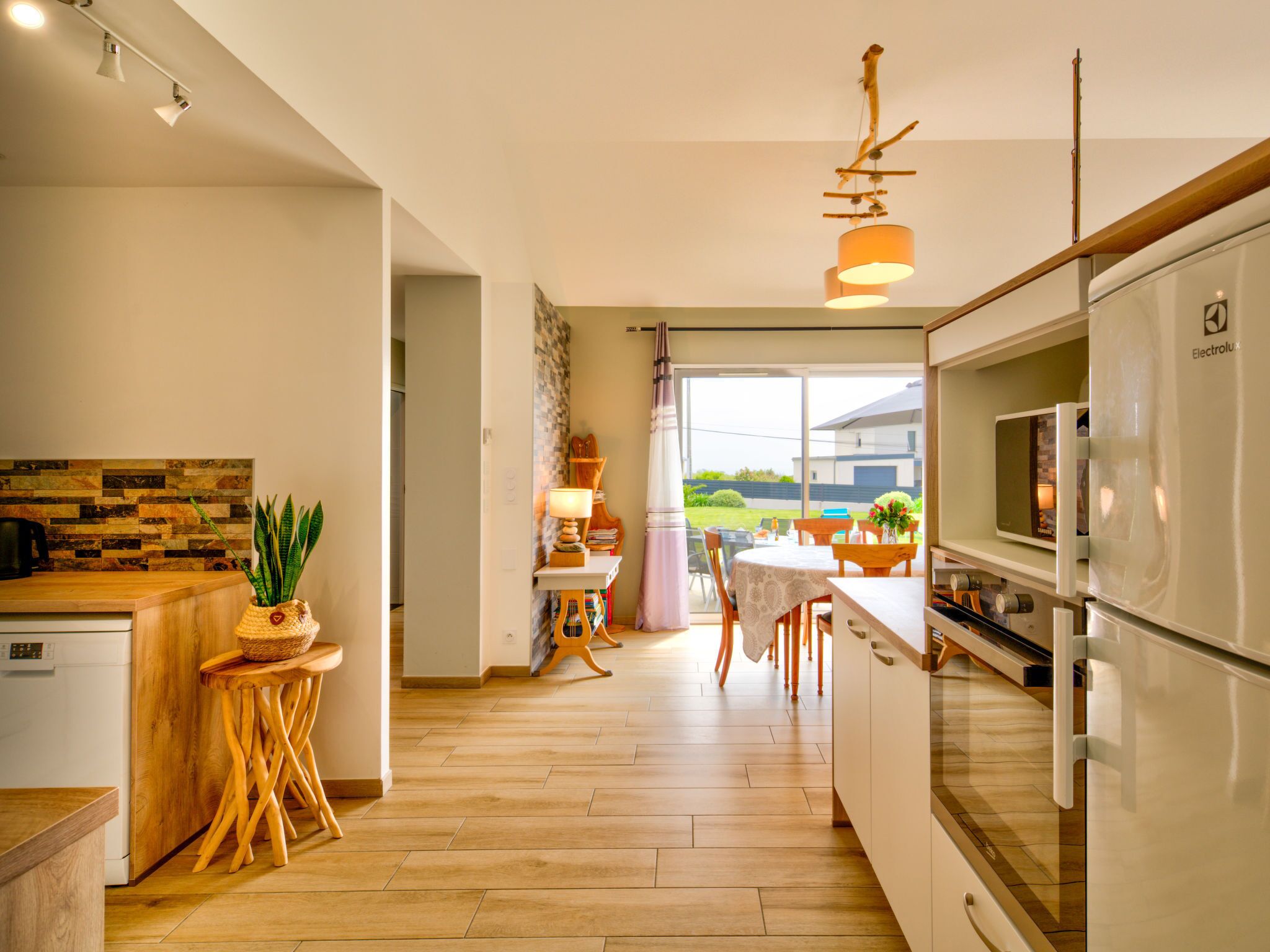 A modern kitchen with a wooden countertop, a built-in oven, and a dining area with a table and chairs.