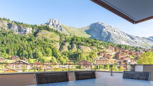 Un balcon avec vue sur un village de montagne et un lac.