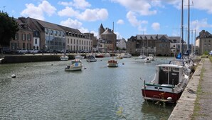 Un port où des bateaux sont amarrés le long de la rive, entouré de bâtiments historiques.