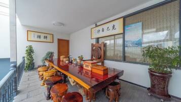Habitación de estilo tradicional con una larga mesa de madera, varios taburetes y una planta en maceta.