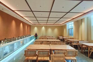 A spacious dining area with long tables and chairs, a central serving counter, and a high ceiling with a grid pattern. - Shengtong Hotel (Lijiang)