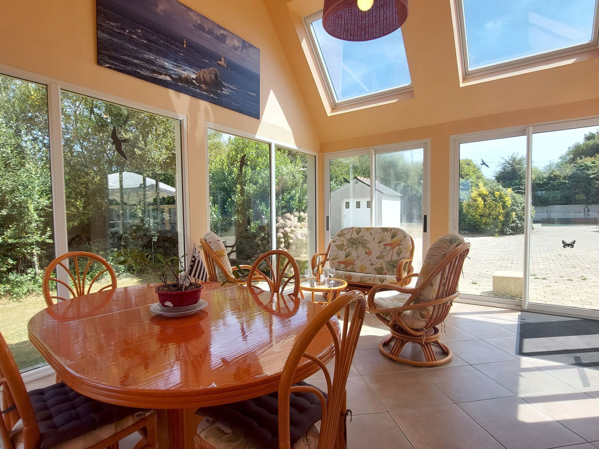 Un comedor con mesa y sillas de madera, ventanas amplias y vistas al exterior.