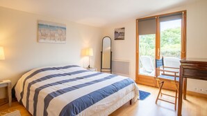 Un dormitorio con una cama grande, una mesita de noche, un espejo y vistas al exterior.