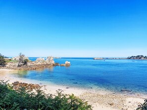 A coastal landscape with clear blue waters, rocky formations, and a sandy beach. - La Rotonde by Interhome (Penvénan)