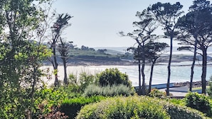 A coastal landscape with a view of the beach, trees, and a clear sky. - Les Courlis by Interhome (Trévou-Tréguignec)