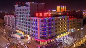 A multi-story hotel with balconies and a brightly lit facade. - Yanhong Hotel (Jiayuguan Xiongguan Plaza) (Jiayuguan)
