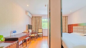 A hotel room with a bed, a desk, a chair, a TV, and a window with curtains. - Yanhong Hotel (Jiayuguan Xiongguan Plaza) (Jiayuguan)