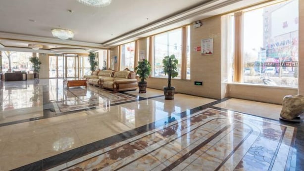 A spacious lobby with a marble floor, a sofa set, potted plants, and large windows. - Yanhong Hotel (Jiayuguan Xiongguan Plaza) (Jiayuguan)