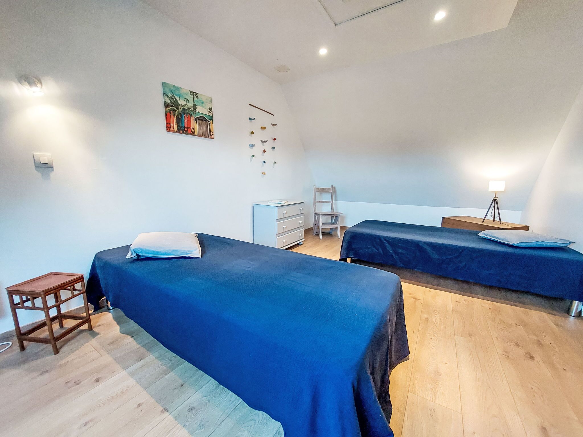 Ein Zimmer mit zwei Betten, einem Schreibtisch, einem Stuhl und einem kleinen Tisch.