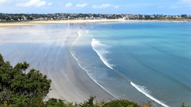 A beach with clear water, a sandy shore, and a town in the background. - L'Egven by Interhome (Saint Cast le Guildo)