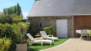 A stone building with a tiled roof, a gravel patio, and outdoor seating. - L'Egven by Interhome (Saint Cast le Guildo)