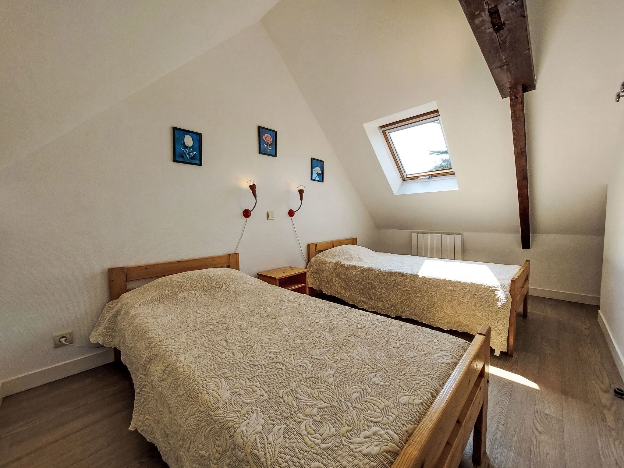 Camera da letto con due letti, un lucernario e una finestra.