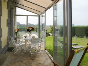 Enjoy a serene atmosphere in this peaceful conservatory with a glass door leading to a patio area.