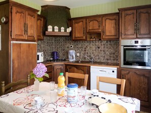Enjoy cooking and dining in this fully equipped kitchen with a microwave, coffee maker, and oven.