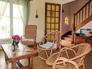Relax in this inviting space with a wooden table, wicker chairs, and a view of the staircase.