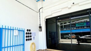 Un garaje con piso de baldosas, una verja azul y un vehículo en su interior.