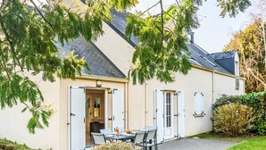 A house with a patio, a dining area, and a small garden.