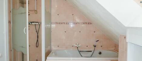 Un baño con ducha, bañera y lavabo.
