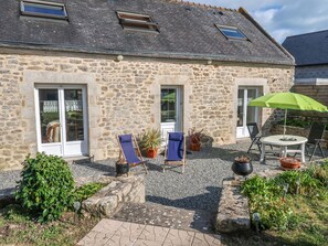 Traditional stone building with a paved patio area, perfect for outdoor dining or relaxation.