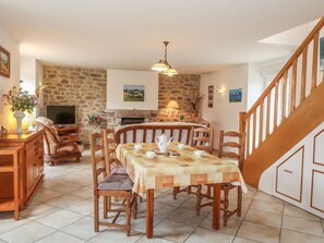 Enjoy meals in this inviting dining area with a fireplace, wooden table, and comfortable seating for four.