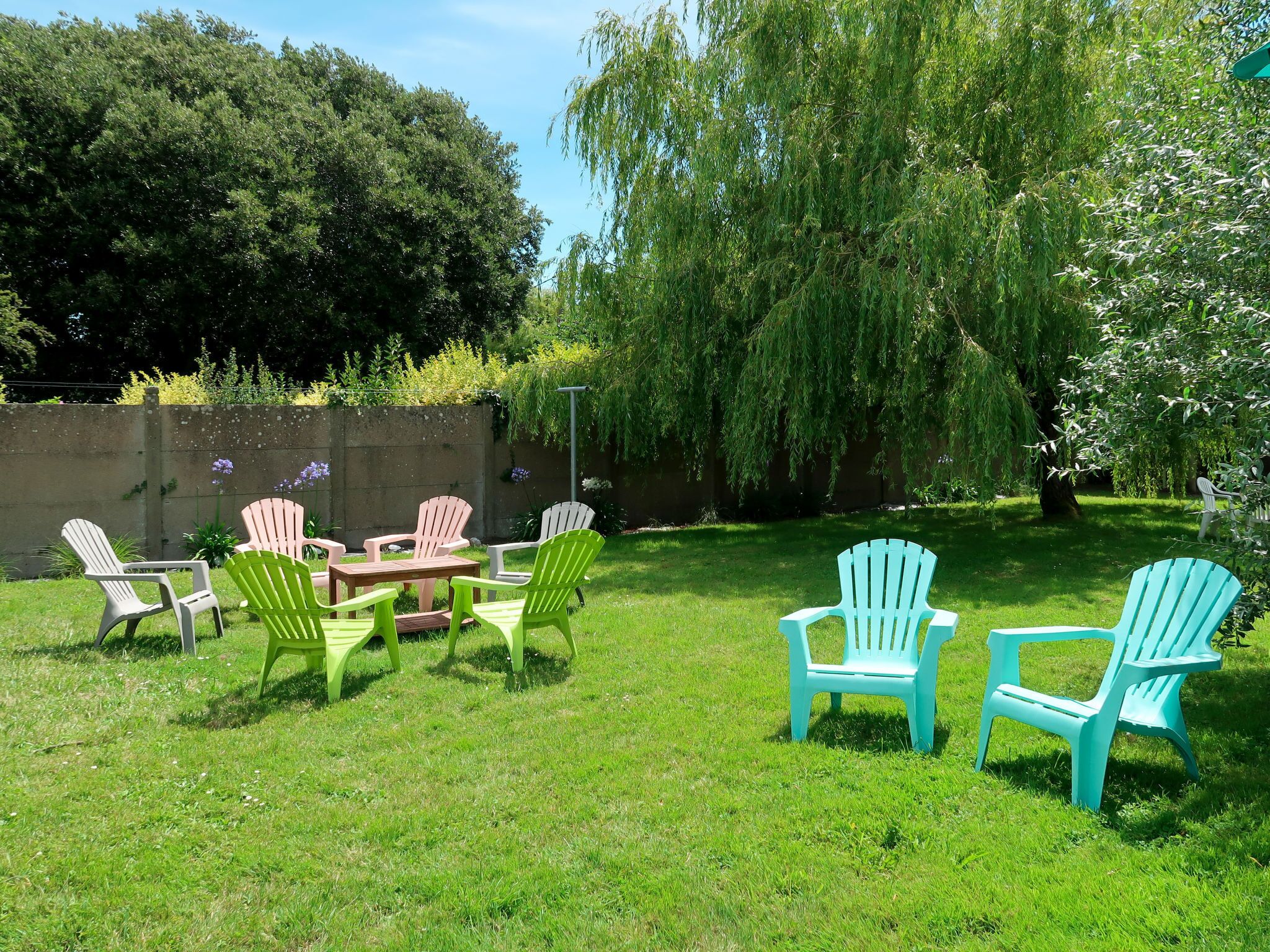 A patio with outdoor furniture and a concrete wall.
