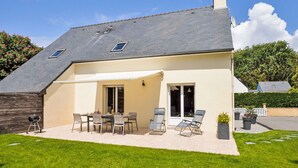 A house with a patio, outdoor seating, and a barbecue grill. - La Farniente by Interhome (La Turballe)
