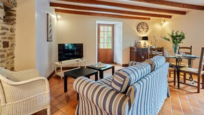 Una sala acogedora con televisor, sofá y comedor.