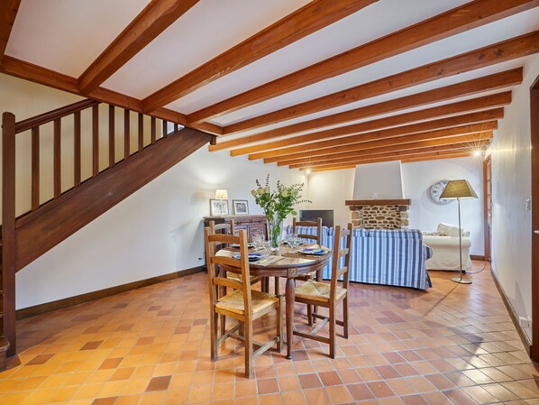 A dining area with a wooden table and chairs, a stone wall, and a staircase. - La Voisinière no.1 by Interhome (Savigny)