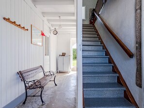 Cozy seating area with a wooden bench and staircase, perfect for relaxation and socializing.