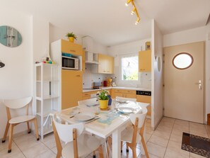 Enjoy cooking and dining in this well-equipped kitchen with a central island, dining table, and microwave, oven, and sink.