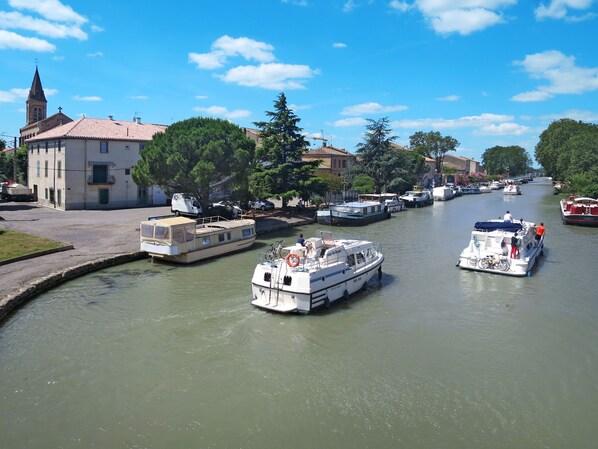A canal with boats, a church, and residential buildings. - Port Minervois by Interhome (Homps)