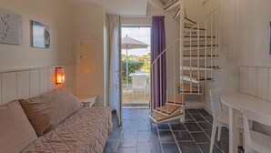 A bedroom with a bed, a desk, and a staircase. - Sud Océan by Interhome (Guidel)