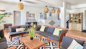 A spacious living area with a sofa set, wooden coffee table, and hanging wicker lamps. - Résidence Odalys Référence La Palmeraie by Interhome (Grimaud)