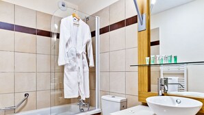 Un bagno moderno con cabina doccia in vetro, un lavandino bianco e un water.
