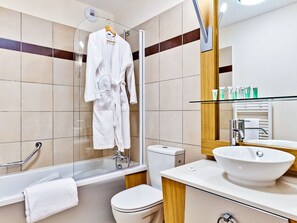 Un baño moderno con ducha de vidrio, lavamanos blanco y retrete.