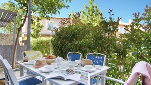 A table set outdoors with a book, cups, and pastries.