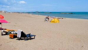 A beach with sun loungers, a yellow tent, and a clear blue sky. - Odalys Essentielle Le Grand Bleu by Interhome (Valras Plage)
