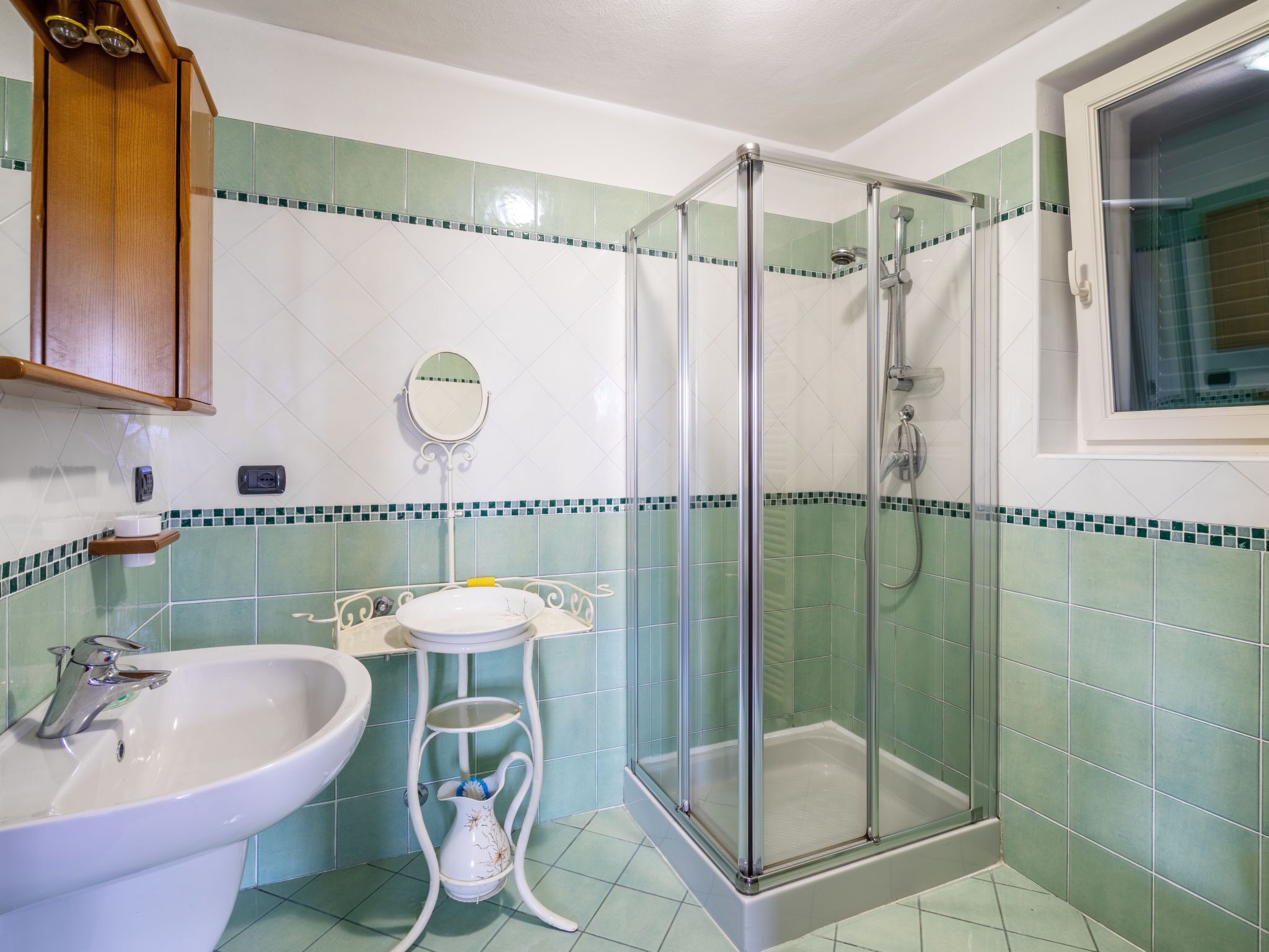 Ein Badezimmer mit Waschbecken, Spiegel und Dusche.