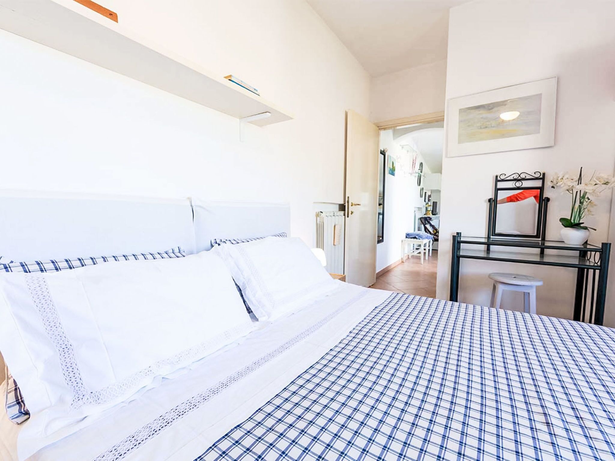 A hotel room with a bed, a desk, a chair, and a small table.