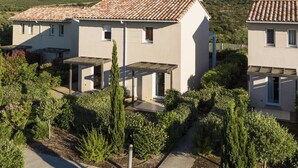 A modern villa with a tiled roof, surrounded by lush greenery and mountains in the background. - Odalys Référence Les Villas Bel Godère by Interhome (Lozari)