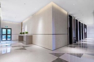 Un vestíbulo moderno con una recepción, una pared grande con un diseño geométrico y un piso limpio y pulido.