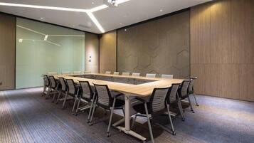 A conference room with a long table, chairs, and a modern ceiling design.